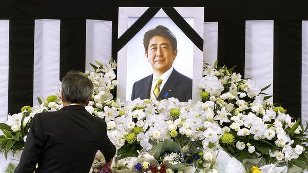 Мужчина у портрета Синдзо Абэ во время церемонии государственных похорон бывшего премьер-министра Японии Синдзо Абэ в Токио - Sputnik Казахстан