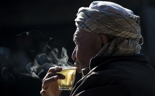 В Афганистане чай пьют из небольших стаканчиков (&quot;ормуд&quot;), фарфоровых чашек или пиал. Как и везде на Востоке, чай пьют, сидя или полулежа на ковре. На фото: афганец пьет чай в Кабуле. - Sputnik Казахстан