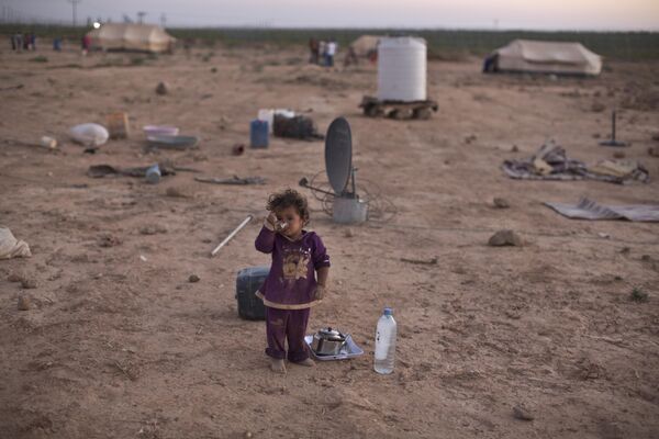 Сирийская девочка пьет чай, стоя возле палатки своей семьи в палаточном поселении недалеко от сирийской границы на окраине Мафрака, Иордания. - Sputnik Казахстан