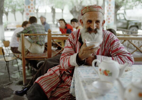 Чайхана в Таджикистане - такой же незыблемый элемент местных традиций, как и само чаепитие. На фото: старожил Таджикистана пьет чай в чайхане районного центра. - Sputnik Казахстан