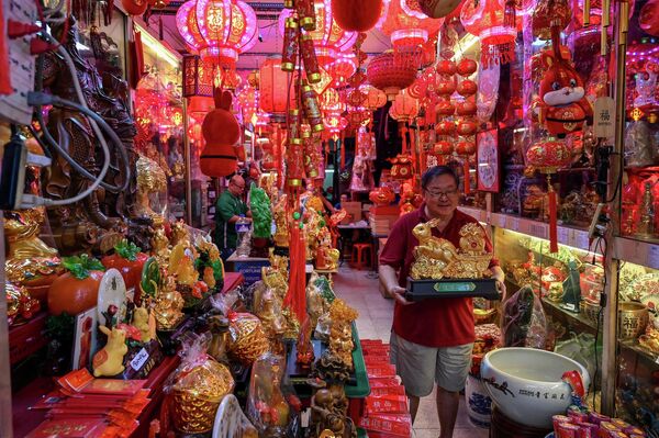 Мужчина несет украшение в магазине в китайском квартале Манилы в преддверии Лунного Нового года Кролика, Филлипины. - Sputnik Казахстан