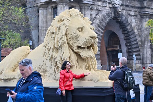 Туристы позируют перед гигантской статуей льва из конструктора Lego, точной копией одной из львиных статуй старейшего в Венгрии Цепного моста в Будапеште. - Sputnik Казахстан