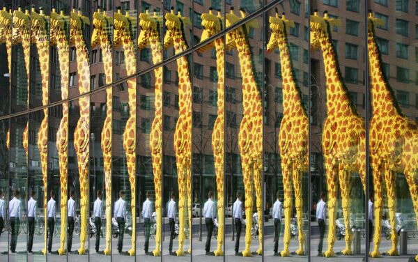 Гигантский жираф, сделанный из кубиков Lego, отражается в стеклянном фасаде в Берлине. - Sputnik Казахстан
