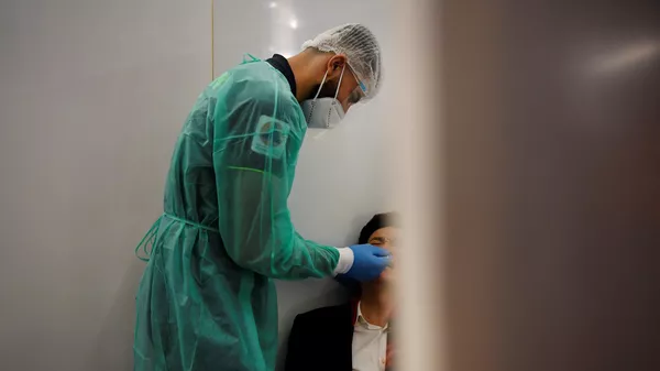 Медик в защитном костюме берет пробу для ПЦР теста на коронавирус - Sputnik Казахстан