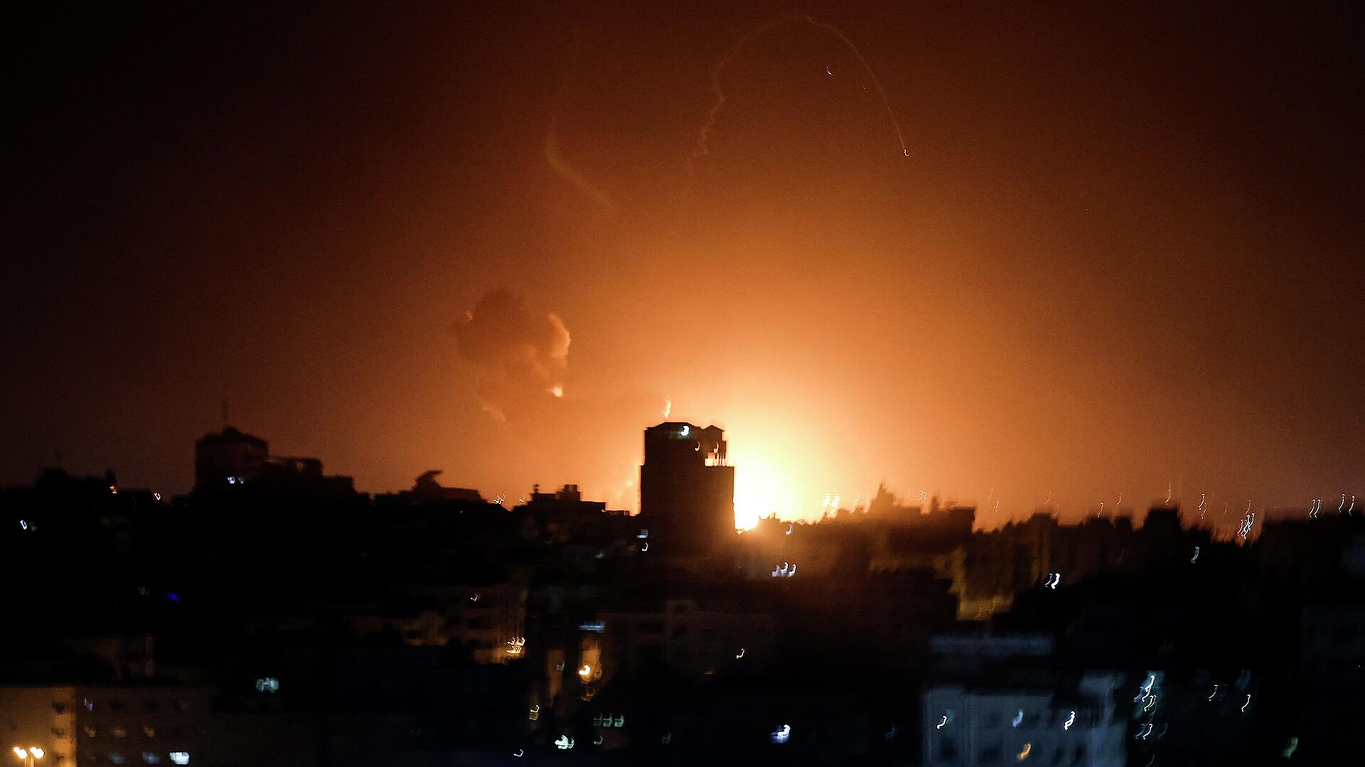 Огонь и дым поднимаются над зданиями в городе Газа, когда Израиль нанес авиаудары по палестинскому анклаву - Sputnik Казахстан, 1920, 02.02.2023