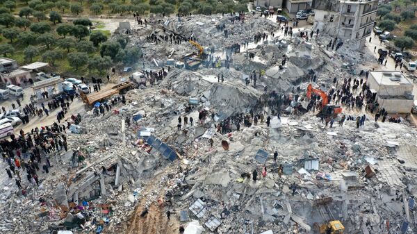 Поиски жертв и выживших среди обломков рухнувших зданий после землетрясения в деревне Бесния недалеко от города Харим, в сирийской провинции Идлиб - Sputnik Казахстан