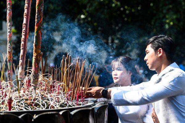 Пара зажигает благовония во время свадебной церемонии в центре Ханоя во Вьетнаме. - Sputnik Казахстан