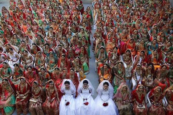 Индийские невесты во время массовой свадьбы в Сурате. Как известно, в Индии свадьба - это дорогое удовольствие. В особенности для девушек. Семья невесты должна обеспечить семье жениха дорогое приданое.  - Sputnik Казахстан