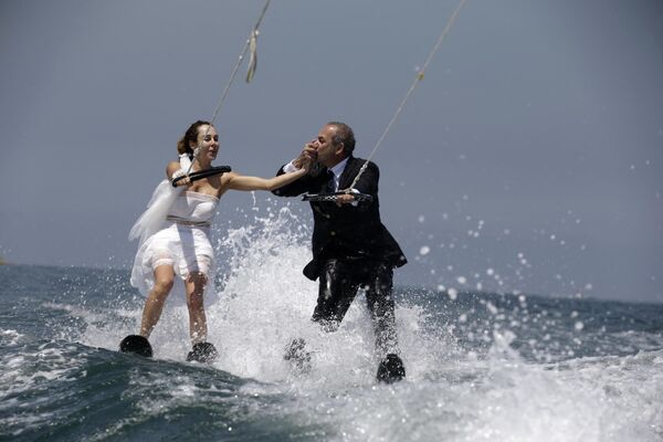 &quot;Неправильная&quot;, но очень веселая свадьба в Ливане: пара молодоженов празднует свадьбу, катаясь на водных лыжах. Платье невесты и смокинг жениха мокры от водных брызг. Но посмотрите, как они счастливы! - Sputnik Казахстан