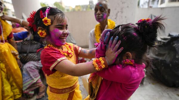 Девочки раскрашивают друг друга пудрой в дни праздника Холи в Калькуте, Индия - Sputnik Казахстан