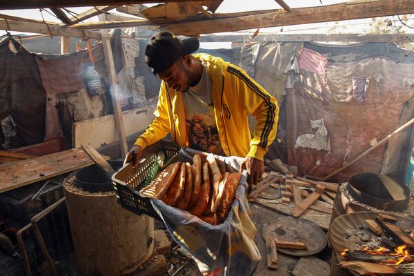 Рамадан — священное время для каждого мусульманина. На фото: мужчина несет свежеиспеченный хлеб тандури во время священного для мусульман месяца Рамадан в восточном ливийском городе Бенгази. - Sputnik Казахстан