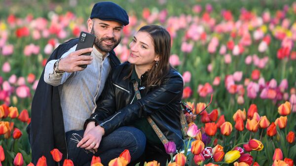 Пара делает селфи в поле тюльпанов в Арезе, Италия - Sputnik Қазақстан