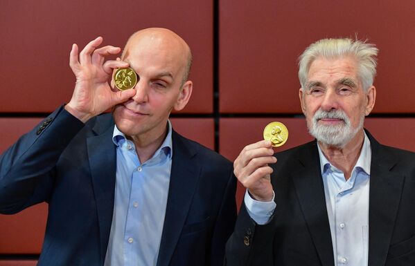 Немецкие лауреаты Нобелевской премии по физике Клаус Хассельманн (справа) и химии Бенджамин Лист (слева) задорно позируют с шоколадными медалями Nobel Prize. - Sputnik Казахстан