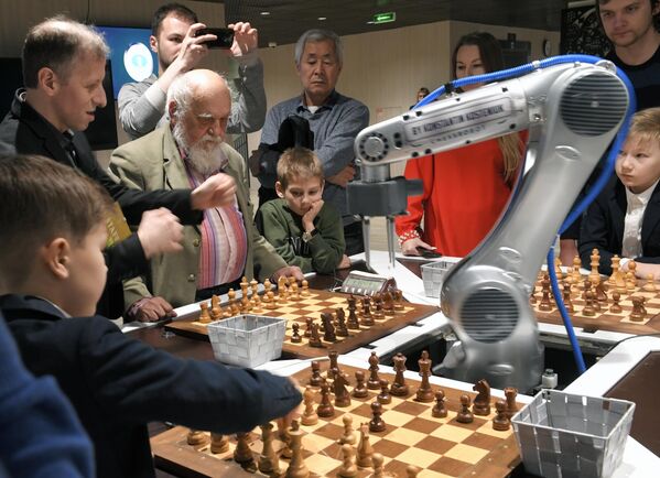 Робот-шахматист играет в шахматы одновременно с тремя посетителями. - Sputnik Казахстан