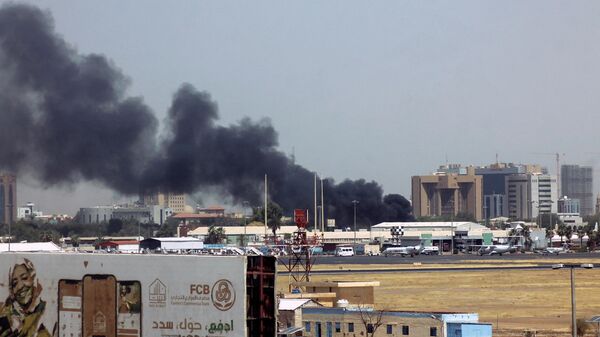 Густой дым над зданиями в районе аэропорта Хартума 15 апреля 2023 года на фоне столкновений в столице Судана - Sputnik Казахстан