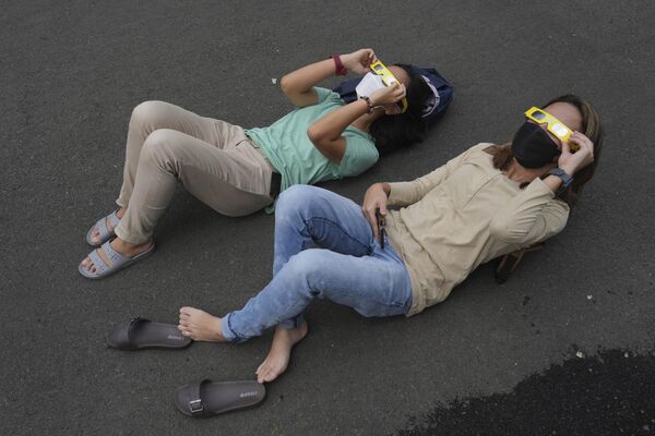 Люди наблюдают за солнечным затмением 2023 года в Джакарте, Индонезия.  - Sputnik Казахстан