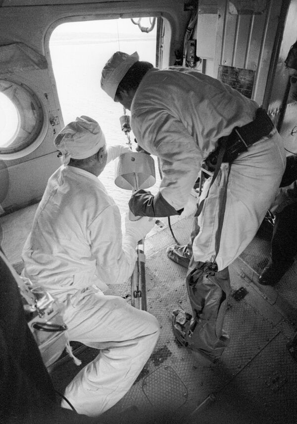 Специалисты с борта вертолета берут пробы воды в охладителях реактора Чернобыльской АЭС после катастрофы - Sputnik Казахстан