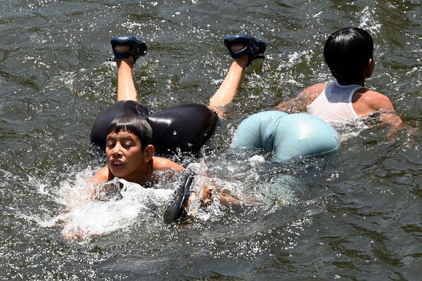 Дети купаются у плотины Равал в жаркий майский день в Исламабаде. Их надувные плавательные средства выглядят забавно и немного двусмысленно.  - Sputnik Казахстан