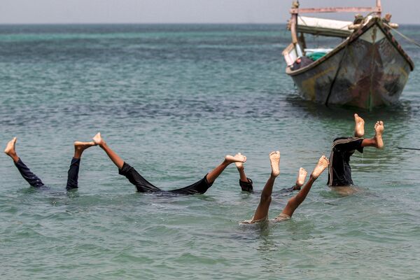 Даже если мир сходит с ума и все перевернулось с ног на голову, стоит найти время для доброй шутки! На фото: мальчики выполняют подводные сальто в Красном море, Йемен. - Sputnik Казахстан