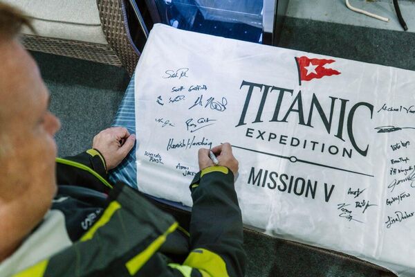 Британский миллиардер и космический турист Хамиш Хардинг подписывает флаг пятой экспедиции к обломкам &quot;Титаника&quot;.Все участники того рокового погружения были состоятельными людьми. - Sputnik Казахстан