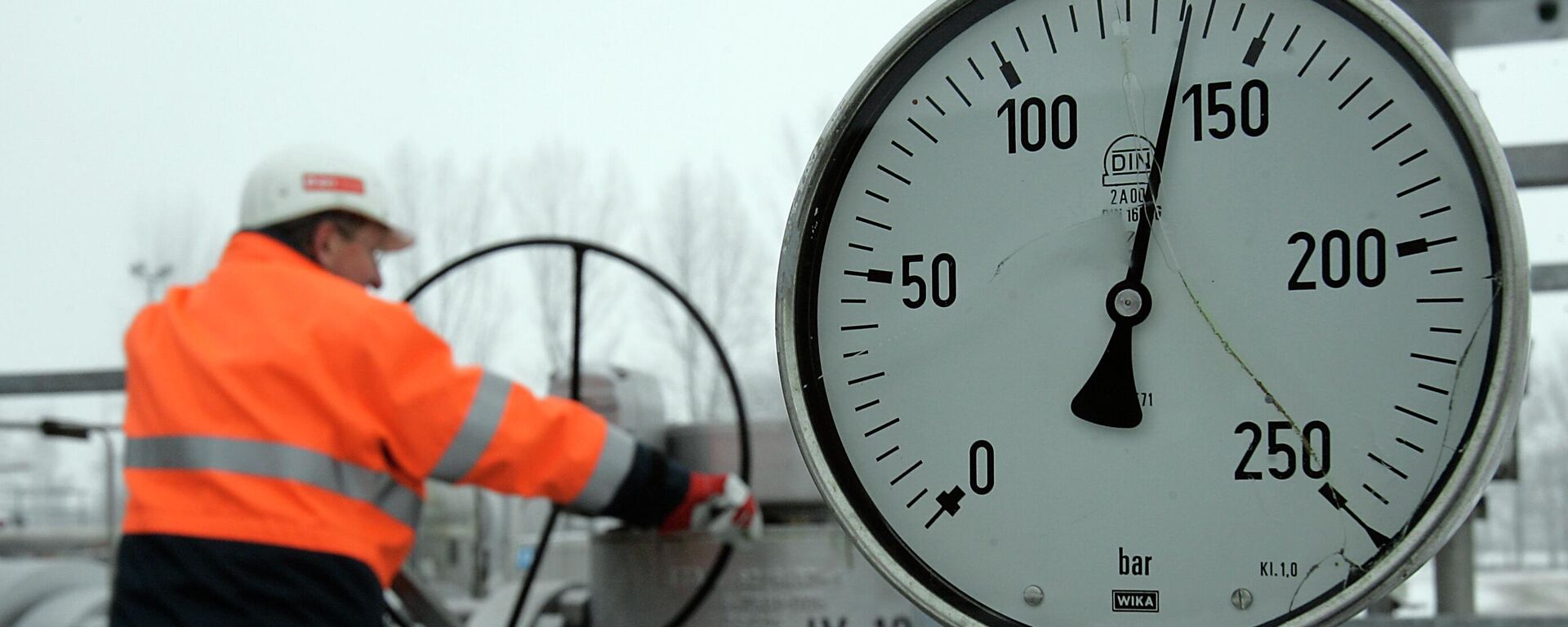 Сотрудник поворачивает вентиль газопровода газохранилища - Sputnik Казахстан, 1920, 07.06.2024