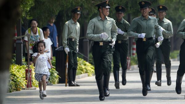 Девочка бежит вместе с членами почетного караула, когда они отрабатывают марш в Пекине, Китай - Sputnik Казахстан