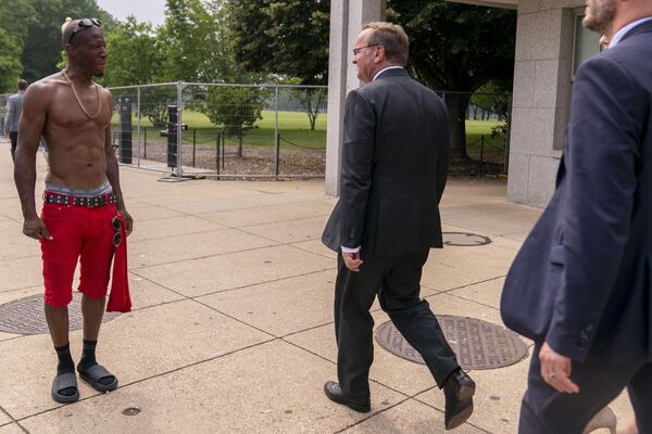 Министр обороны Германии Борис Писториус проходит мимо мужчины без рубашки в Вашингтоне, США.  - Sputnik Казахстан