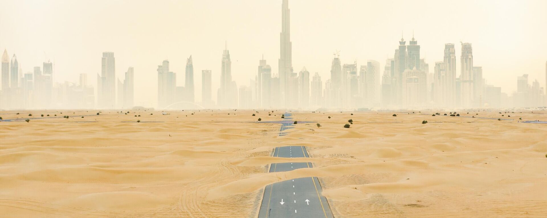 Пустынная дорога, покрытая песчаными дюнами в Дубае, ОАЭ - Sputnik Казахстан, 1920, 28.09.2023