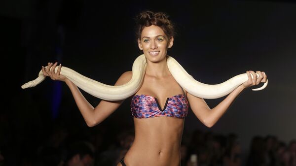 Модель с живой змеей во время показа Mercedes-Benz Fashion Week Swim в Майами-Бич, штат Флорида, США - Sputnik Казахстан