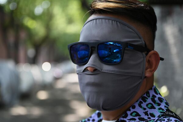 Мужчина в защитной маске и солнцезащитных очках во время жаркой погоды в Пекине.  - Sputnik Казахстан