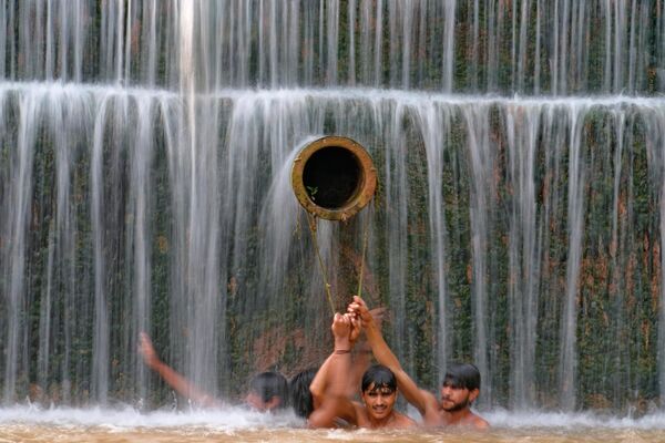 Юноши освежаются в водопаде, когда температура достигла 36 градусов по Цельсию в Исламабаде, Пакистан. - Sputnik Казахстан