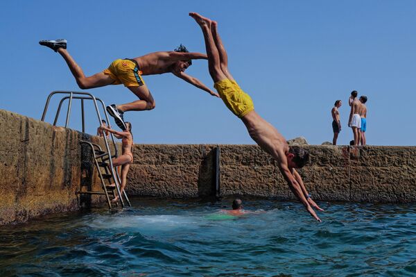 Люди прыгают в Средиземное море на французской Ривьере в городе Ницца. - Sputnik Казахстан