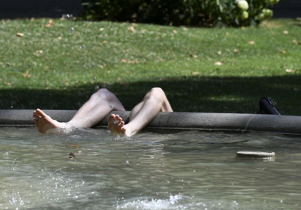 Мужчина охлаждает ноги в фонтане в центре Загреба, Хорватия. - Sputnik Казахстан