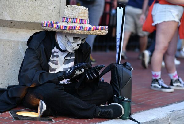 Мужчина, в костюме скелета, проверяет свой телефон во время международного фестиваля Comic-Con в Сан-Диего, США. - Sputnik Казахстан