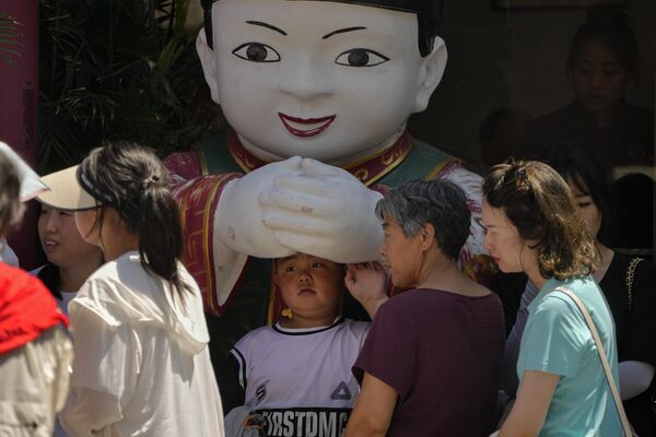 Мальчик прячется возле статуи в жаркий день в Пекине, Китай. - Sputnik Казахстан