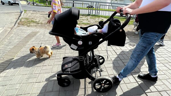Родители переходят дорогу с детской коляской, архивное фото - Sputnik Казахстан
