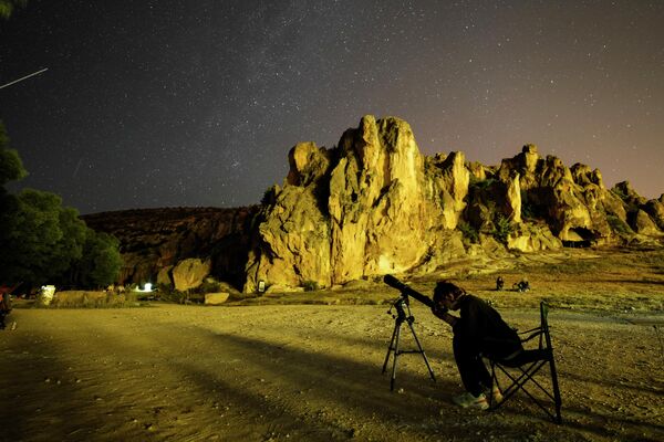 Частички пыли и мелких камней, оставленных кометой на своем пути, входят в земную атмосферу и вызывают световые вспышки, которые мы называем метеорами. На фото: люди наблюдают за метеорным потоком Персеид в Турции, в 250 км от Анкары.  - Sputnik Казахстан