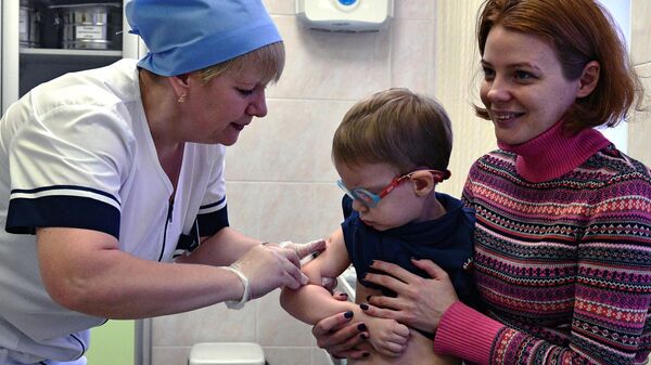 Медицинская сестра делает прививку от кори ребенку в детской поликлинике - Sputnik Казахстан