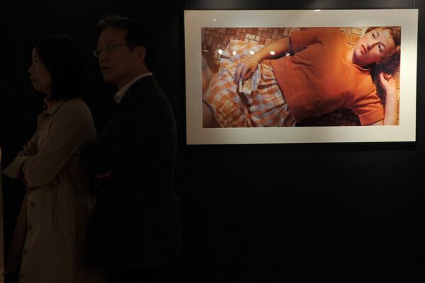 На фото: мужчина и женщина стоят рядом с фото Синди Шерман Untitled #96 на пресс-показе в Гонконге, Китай. Этот снимок, стоимостью 3 890 500 долларов,  один из самых известных и дорогих работ этого автора. Снимок был приобретен на аукционе Christie’s в 2011-м году неизвестным коллекционером. - Sputnik Казахстан