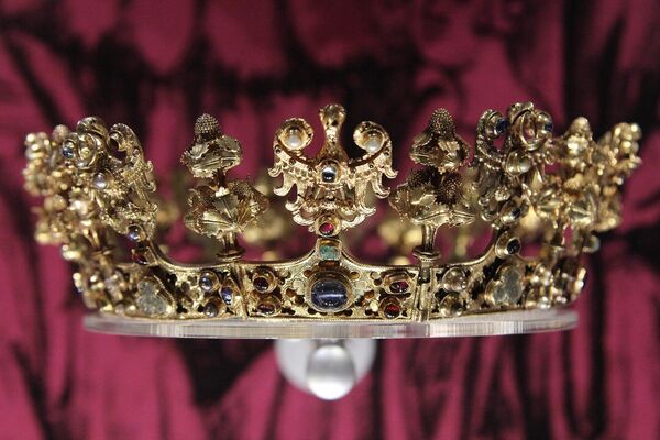 Золотая женская свадебная корона из сокровищ Шроды. Клад состоит из серебряных и золотых монет, а также золотых украшений и некоторых драгоценных камней и датируется серединой XIV века. Сокровища были найдены в 1985–1988 годах в Польше.  Считается, что сокровища принадлежали королю - императору Карлу IV из Королевского Дома Люксембурга. Клад считается чрезвычайно ценным, и некоторые описывают его как &quot;одну из самых ценных археологических находок XX века&quot;. - Sputnik Казахстан