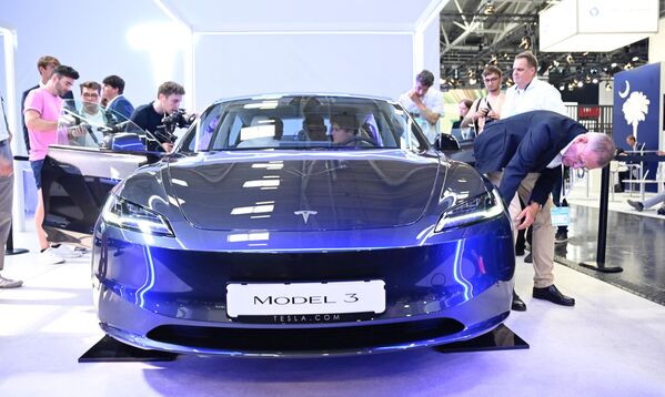 Электрлі көк түстегі Tesla 3 көлігі Мюнхендегі халықаралық автосалонда көптеген келушінің назарын аударды. - Sputnik Қазақстан