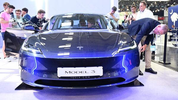 Посетители осматривают автомобиль Tesla model 3, выставленный на Международном автосалоне в Мюнхене - Sputnik Казахстан