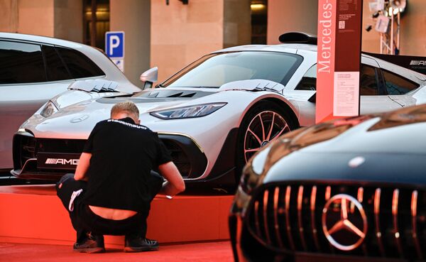 Рабочие наносят последние штрихи на стенде Mercedes рядом с автомобилями Mercedes AMG на Международном автосалоне в центре Мюнхена. - Sputnik Казахстан
