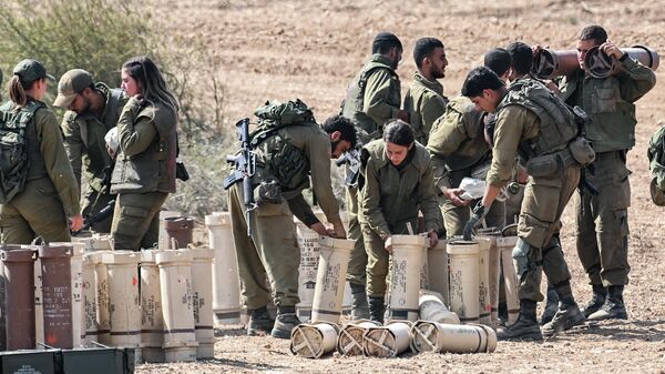 Солдаты израильской армии справляются с артиллерийскими снарядами на позиции недалеко от сектора Газа на юге Израиля - Sputnik Қазақстан
