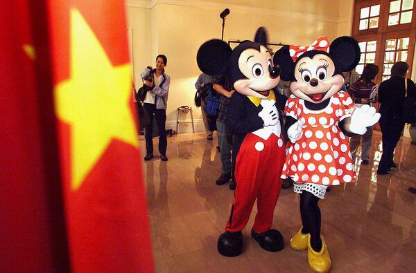 The Walt Disney — одна из известнейших компаний мира, которая занимает 53-е место по размеру выручки в списке Fortune 500 за минувший год, Микки-Маус в качестве корпоративного символа компании. На фото: Микки и Минни-Маус на экскурсии по Дому правительства Гонконга, 1999 год.  - Sputnik Казахстан