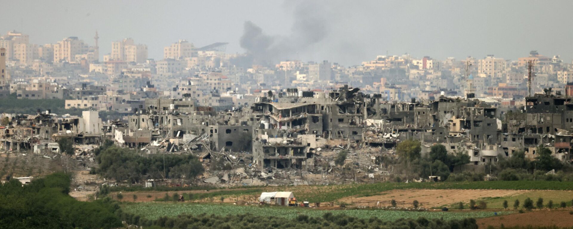 На снимке, сделанном в южно-израильском городе Сдерот, видны разрушенные здания на севере сектора Газа на фоне продолжающихся боев между Израилем и палестинской группировкой ХАМАС - Sputnik Казахстан, 1920, 18.10.2023