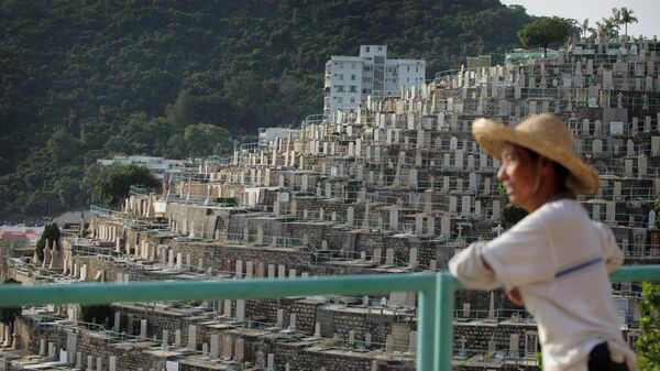 Мужчина смотрит на кладбище Пок-Фу-Лам в Гонконге - Sputnik Қазақстан