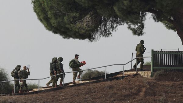 Израильские солдаты поднимаются на холм в Сдероте на юге Израиля - Sputnik Казахстан