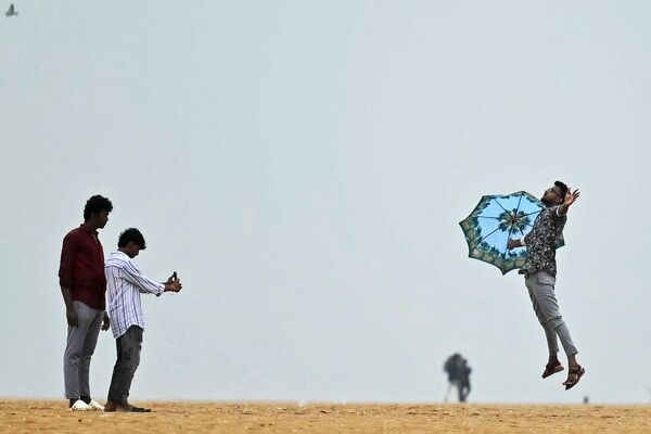 Юноша фотографировался на пляже Марина во время дождя в Ченнаи, Индия. - Sputnik Казахстан