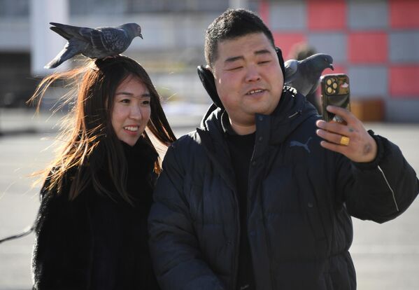 Туристы делали селфи с голубями на Центральной площади во Владивостоке. - Sputnik Казахстан